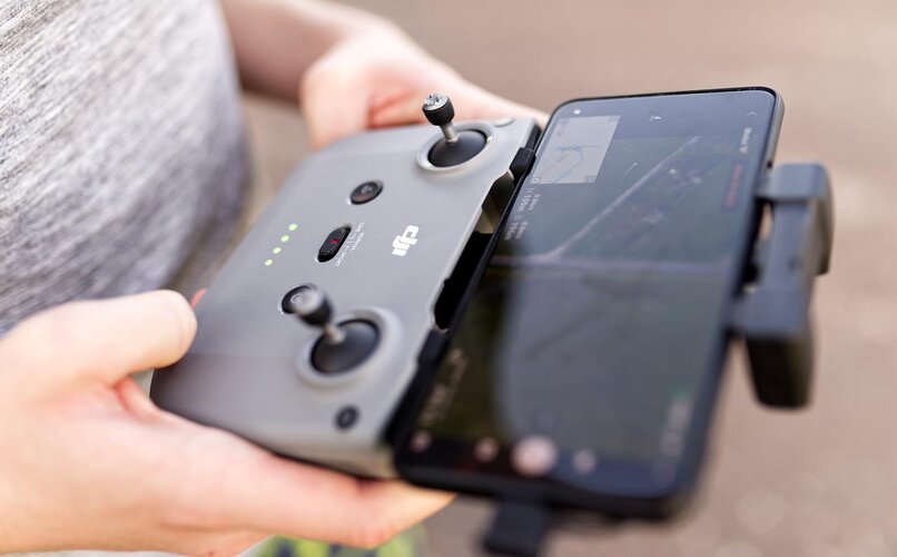 hombre manejando dron via mando a distancia