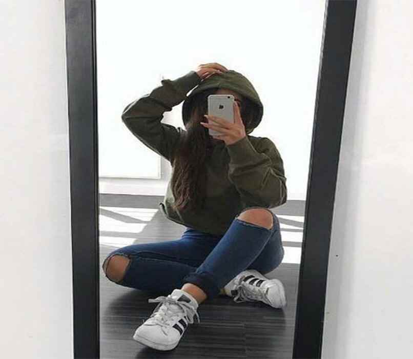 posa frente a un espejo